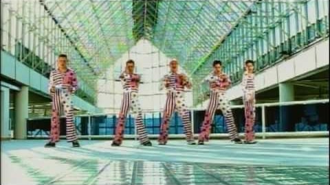 The five members of 2gether dancing in matching striped outfits in the U + Me = Us music video.